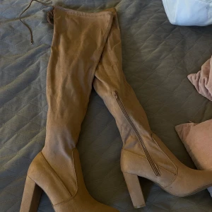 Dam mockastövlar - Långa mockastövlar (inte äkta mocka), bekväm och stor klack och med snören där man kan spänna stövlarna. Stövlarna är helt nya och inte använda. 