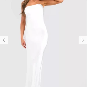 Vit satin Bandeau klänning - Så sjukt fin bandeauklänning i satin material, lapparna kvar och helt oanvänd. Säljer då jag inte känner att Bandeau kläder passar min kroppsform. Storlek 40 men skulle säga passar 38 också. Skriv för frågor eller funderingar 🩷