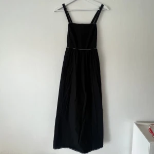 Svart långklänning zara xs  - Jättesöt!! Med vita sömmar, öppen rygg & knytning, dragkedja i bak. Oanvänd, vara testad. 