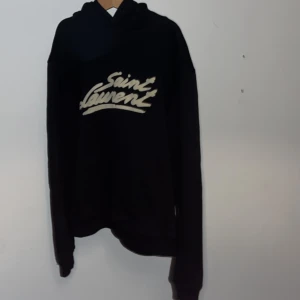 Saint Laurent hoodie - Säljer denna sjukt snygga Saint Laurent hoodie till bra pris✨skick 8/10 då snörena tyvärr är borttappade men det går enkelt att fixa hos en skräddare🧶 Storleken är S men passar även XS📏 Hör av er vid minsta fråga⭐️