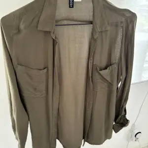 Militär-grön mjuk skjorta från H&M Divided i storlek 32. Köpt för cirka 5 år sedan och skulle säga att den passar XS bäst!