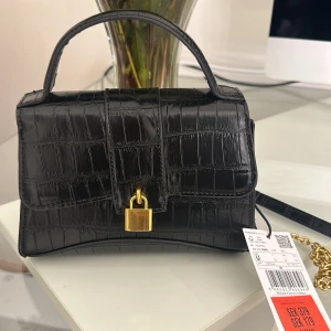 Fin liten väska   - Liten svart axelväska som har band, från mango aldrig använt då prislapp finns kvar köpt för 179 och därav säljer för samma pris.