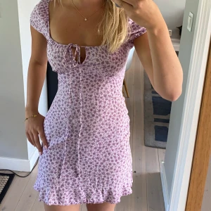 Lila sommarklänning - Världens gulligaste sommarklänning! Önskar jag kunde ha kvar men tyvärr lite liten på mig numera. Storlek 32 eller XXS, men tycker den funkar även om man är XS. Från Motel Rocks Lila med blommor och justerbart snöre vid brösten!🌷