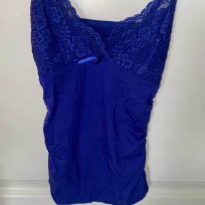 Spets linne - Ett kungsblått linne med spets, den har lite sceunch på sidorna som formar midjan så fint!