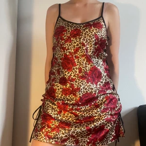 Mönstrad nattlinne/klänning - Nattlinne/klänning i leopardmönster med röda rosor på. Storlek 38/40 men går att justera hur den sitter med snörning på sidorna. Möts på söder eller postar. Skriv innan ni trycker på köp nu då jag är bortrest en del i sommar. 
