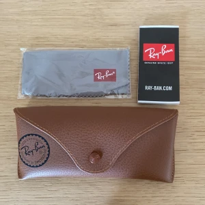 Rayban fodral läder - Säljer ett sprillans nytt Rayban läder fodral. Det är alltså helt nytt. Fiberduk tillkommer. Nypris 450kr Mitt pris 179kr