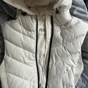 Vit zara väst - Säljer min vita zara väst då jag rensat ut min garderob och hittade denna som inte kommer till användning. Den är använd hyfsat mycket förra året och har råkat få en bronser fläck vid fickan, men annars är den i bra skick 
