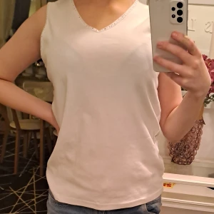 Vitt linne med glittrig sömm - Vitt luftigt linne med glittrig sömm för sommarn. Från Joy      !Oanvänd! Storlek M/L Orginalpris:- 89