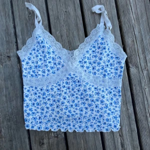 Blommigt sommarlinne - Vitt, blommigt linne till sommaren  Material: Polyester  Mönster: Blommigt Annat: Har används men är i gott skick!  Frågor? Bara att ställa!