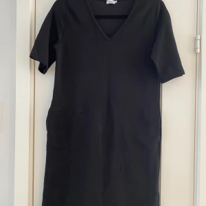 Svart klänning från Filippa K i strl S modell double face t-shirt dress i nyskick  - Endast använd en gång och är i nyskick.  Mått Över bröstet: ca 46 cm Längd från axeln och ner: ca 93 cm  45% lyocell, 42% bomull och 13% elastan  Kommer från ett djur och rökfritt hem.