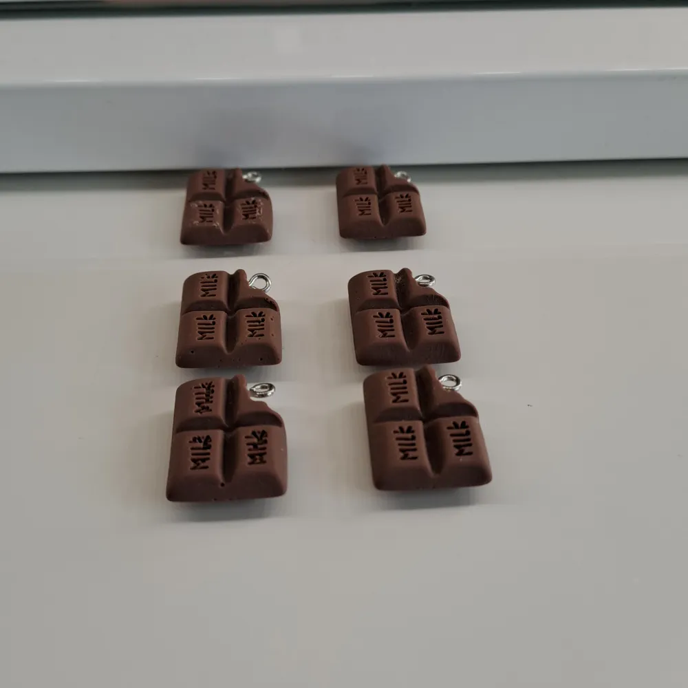 Köparen får med sammanlagt 12st choklad berlocker i färgerna vit och brun😊. Accessoarer.