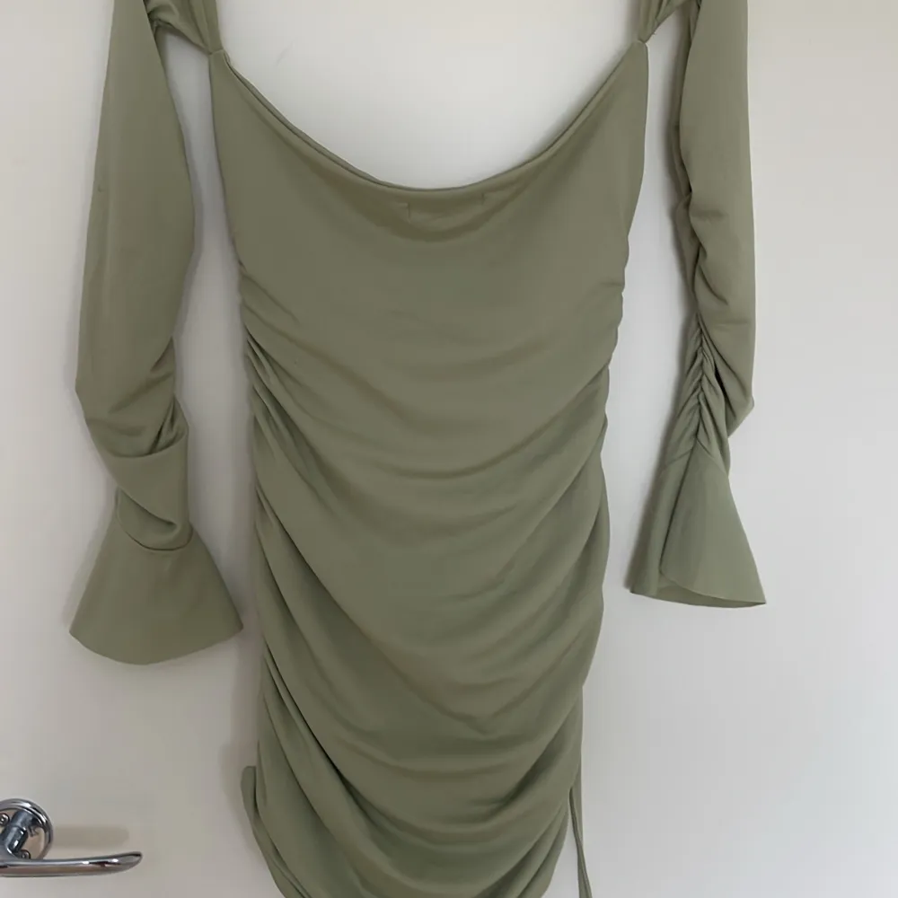 En ljus grön klänning som både är off shoulder och långärmad, kort i storlek S aldrig använd.. Klänningar.