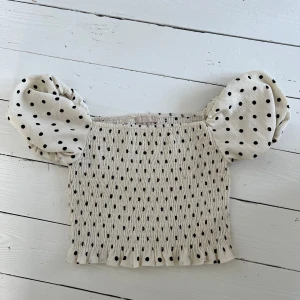 Prickig topp - Söt prickig topp med puffiga ärmar från hm. Materialet är stretchigt