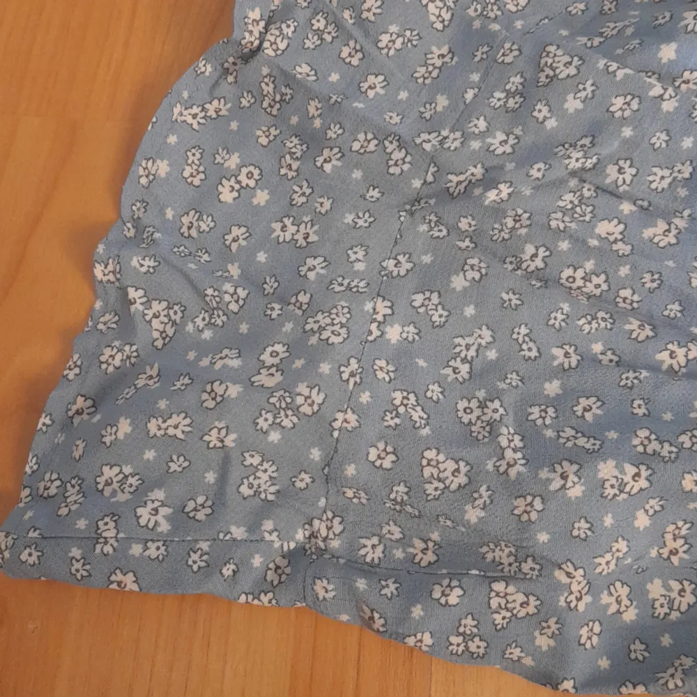En kjol med shorts under. Kjolen är ljus blå med söta små vita blommor. Den har knyt funktion fram till och bak till så är den stretchig. Kjolar.