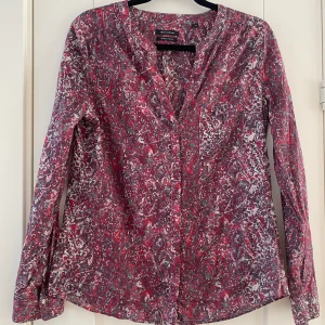 Röd och grå mönstrad tunnare blus från Marc O’Polo i strl 40 - Ny, aldrig använd.  Mått Över axeln: ca 43 cm Längd från axeln och ner: ca 66 cm  Kommer från ett djur och rökfritt hem 