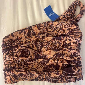 One-shoulder topp - Säljer nu denna fina one-shoulder topp då den är något stor på mig. Köpt på Sellpy och har aldrig använt den