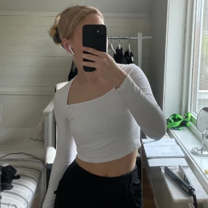 långärmad vit tröja  - En långärmad vit tröja som är croppad i modellen 