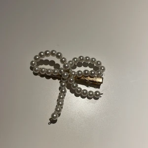 Hårspänne - Gulligt hårspänne med vita pärlor som är formad som en rosett. Pris kan diskuteras 