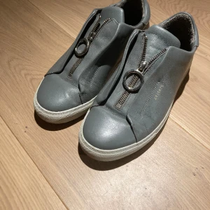gråa arigato skor - ursöta skor från arigato. notera: det finns missfärgningar på insidan av skorna, med detta syns sällan vid användning. finns även en liten repa på högra skons framsida. i och med detta är priset självfallet diskuterbart! älskar dessa men de är för stora