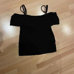 Svart tröja med spetts - Svart ”t-shirt” med spetts i storlek 164/170, 14år. Nyskick med inga defekter, banden är justerbara. Priset kan sänkas vid intresse 