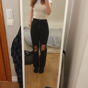 Svarta straight highwaist jeans med hål - Highwaist och straightlegged med hål på knäna. Har sått på lite trådar vid knäna för att får mer trådar. Använda men inga tydliga defekter. Säljer pga försmå och ej min stil längre.