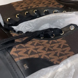 Michael kors ankel boots - Brea monogram-print ankle boots, Michael kors. Oanvända, kvitto finns.   Mörkbrunt läder Brea ankelstövlar med monogramtryck från MICHAEL MICHAEL KORS med rund tå, snörning framtill, märkes-innersula och låg klack.  100 % läder   Kontakta för bilder 