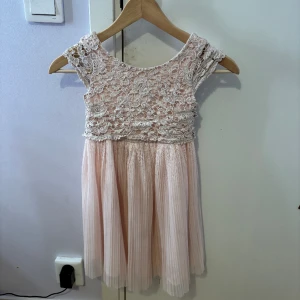 Rosa blommig mönstrad fest klänning - Denna klänning användes senast för ca. 4 år sedan. Uppskattning i ålder från 5 till 6 år. Denna klänning är normal i storlek.