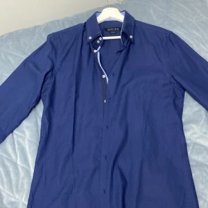 Blå Skjorta från Zara - Säljer en Blå skjorta ifrån Zara som köpts utomlands. Perfekt skick i storlek M Skjortan funkar till kostym samt vardagligt 