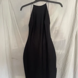 Svart miniklänning  - Svart klänning med öppen rygg. Går en liten bit nedanför rumpan. Plagget är i bra skick. 