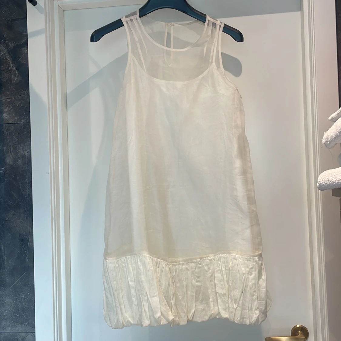 Vit ärmlös klänning med volangdetalj