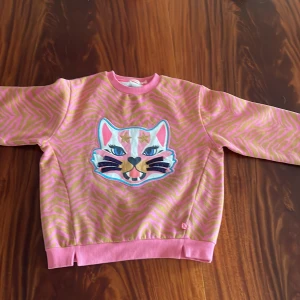 Färgglad tjocktröja 🏳️‍🌈🌈  - Rosa och orange tjocktröja med en färgglad katt, storlek 150 ✨🏳️‍🌈🌈