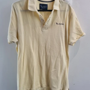 Bondelig piké - Ljust gul Bondelid piké, storlek M. Använd men i bra skick.