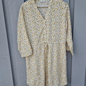 Blommig klänning  - PIGALLE- ONLY- Slutsåld   Underbart fin somrig knälång klänning i stl 38. Dragsko I midjan och trekvartsärm, sparsamt användt. Utan anmärkningar.