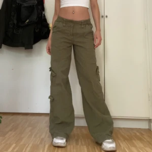 Lågmidjade cargobyxor - Lågmidjade gröna Cargobyxor från Urban Outfitters. Bra skick! Färgen stämmer bäst på sista bilden. Sitter ett snöre på insidan så dem är justerbara i midjan. Skriv om du har frågor eller vill ha fler bilder. 