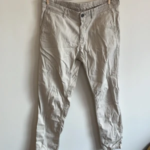 Beige byxor från Zara Man - Ett par beige byxor från Zara Man. Byxorna har en klassisk design med fram- och bakfickor samt en knapp och dragkedja i midjan.