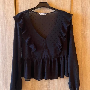 Prickig svart blus - Svart gullig blus med prickar och volanger på sidorna✨nyskick