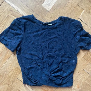 Blå festtopp zara - Kort festtopp, blå. I mesh med mönster. Knytdetalj i fram. Kortärmad.