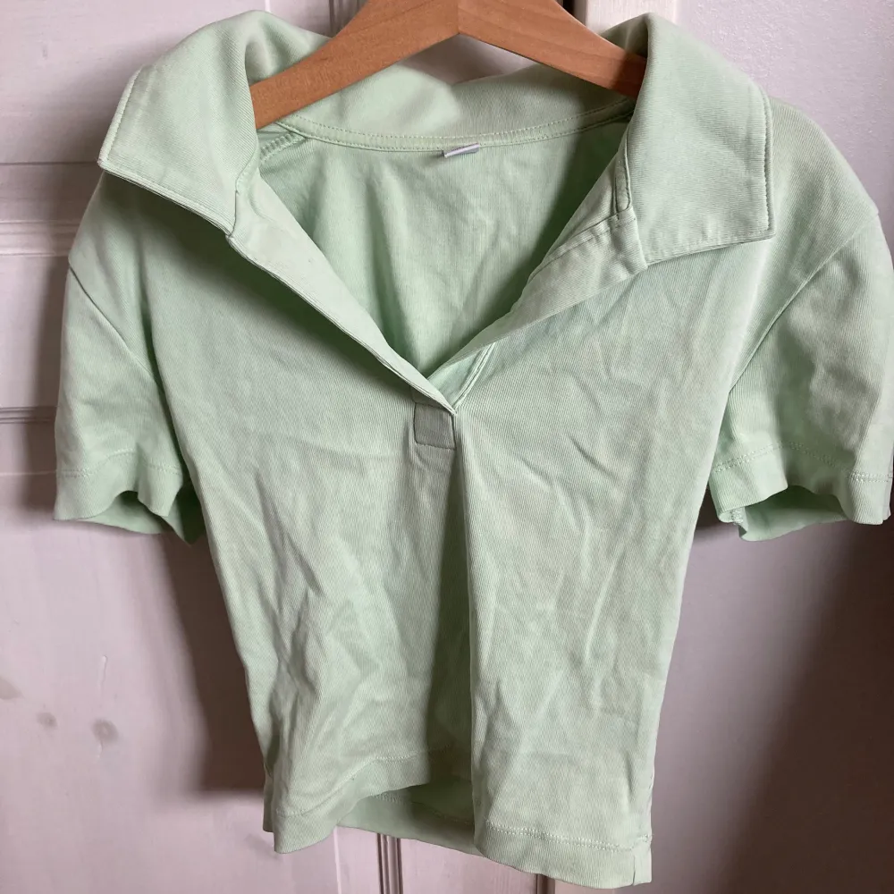 En grön baby t-shirt från uniqlo den är använd ungefär 20-30 gånger men är som i ny skick den har inga fläckar och inga hål :) . T-shirts.