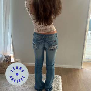 Jeans med tryck på bakfickorna, storlek: W27, midjemått: 37 cm, innerbenlängd: 80 cm. 