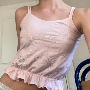 Ljus rosa topp - Så ljus rosa topp från NEXT med fjäril söm och små regnbågs reflekterande paljetter💞 Volang runt nedersta delen💞 Perfekt till sommaren  