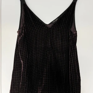 Fintopp silke, Massimo Dutti, 36, brun - Fintopp i silke från Massimo Dutti i storlek 36. Toppen är brun velour med silvriga strassdetaljer. Utsvängd modell. Toppen är i nyskick, använd max 2 ggr.   Material: 72% viskos, 22% silke, 6% polyamide   Mått: Längd ca 65 cm Byst ca 45 cm Midja ca 