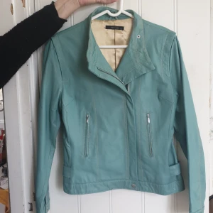 Skinnjacka - Turkos skinnjacka i stl 38, knappt använd. Det enda är sömmen som gått upp en liten bit längst ner på jackan annars superfint skick!