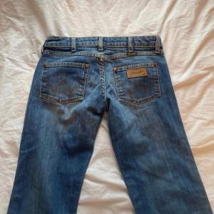 Lågmidjade bootcut jeans, märke Wrangler.  Innerbenslängd - 77  Midja - 36 Höft - 40 