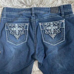 Y2k jeans - Lågmidjade Y2k jeans med utsvängda ben och mönster på fickorna✨