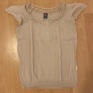 Blus  - Är i tunt material occh beige. Fint skick, skriv till mig vid frågor. Köpt secondhand.
