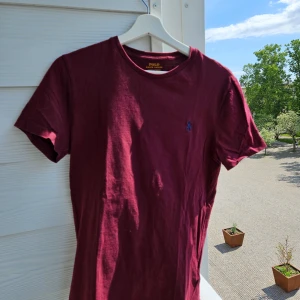 T-shirt från Ralph Lauren  - Vinröd t-shirt från Ralph Lauren i slim model. Varan är i bra skick 