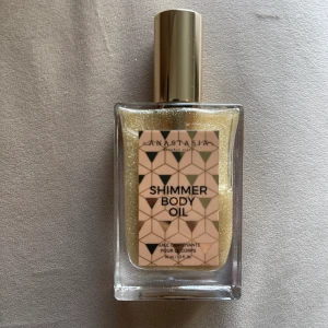 Anastasia shimmer body oil 45ml - Fin kroppsolja i guld som luktar så gott, helt slutsåld och nypris var 465 kr. Säljer pga har en annan jag redan använder!
