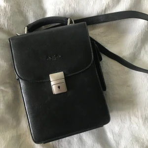 Svart läder väska  - Väldigt stadig svart läderväska. Ingen nyckel finns och behövs inte för att öppna. Kan ses i sthlm o. Du vill köpa! :)