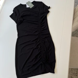 Klänning ny - Ny klänning svart med rynkeffekt på sidan