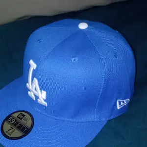 New Era LA Dodgers blå och vit på loggan Basic 59FIFTY Fitted keps.  Storlek 58,7 cm (7⅜) och helt ny, aldrig använd. Ordinarie pris är 599 kr